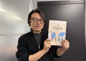 経済法令研究会様「海外展開支援 入門コース」の冊子を持つ世界へボカン代表・徳田祐希
